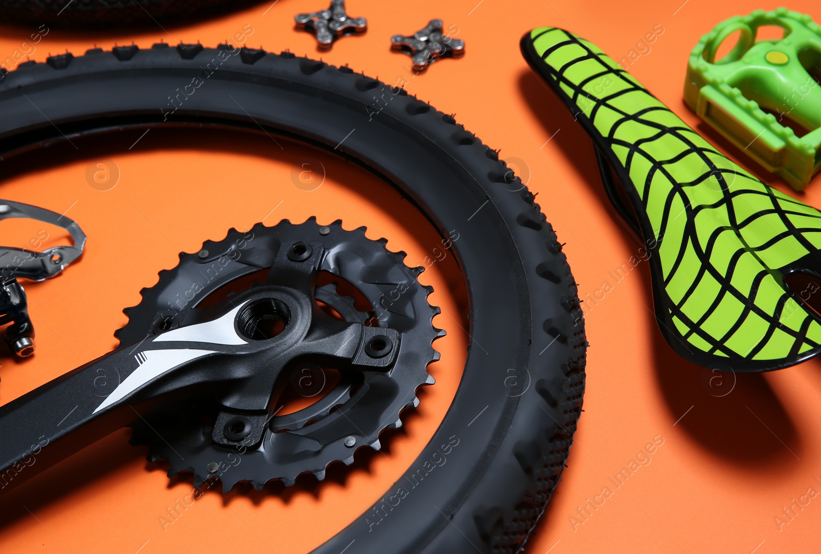 Photo of Set of different bicycle parts on orange background, closeup