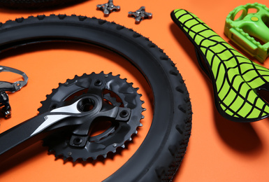 Photo of Set of different bicycle parts on orange background, closeup