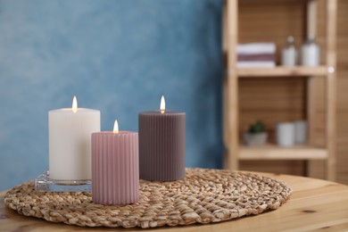 Photo of Beautiful candles on wooden table indoors, space for text