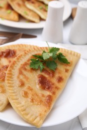 Photo of Delicious fried cheburek with cheese and parsley on white tiled table, closeup