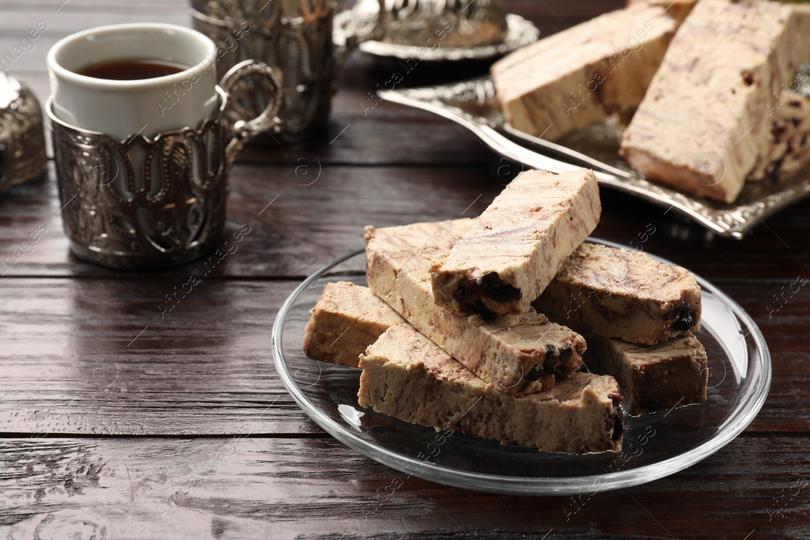 Photo of Pieces of tasty chocolate halva on wooden table