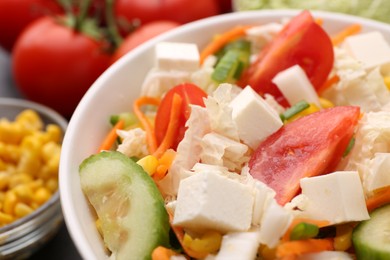 Photo of Tasty salad with Chinese cabbage, carrot, cheese, cucumber and tomato on table, closeup