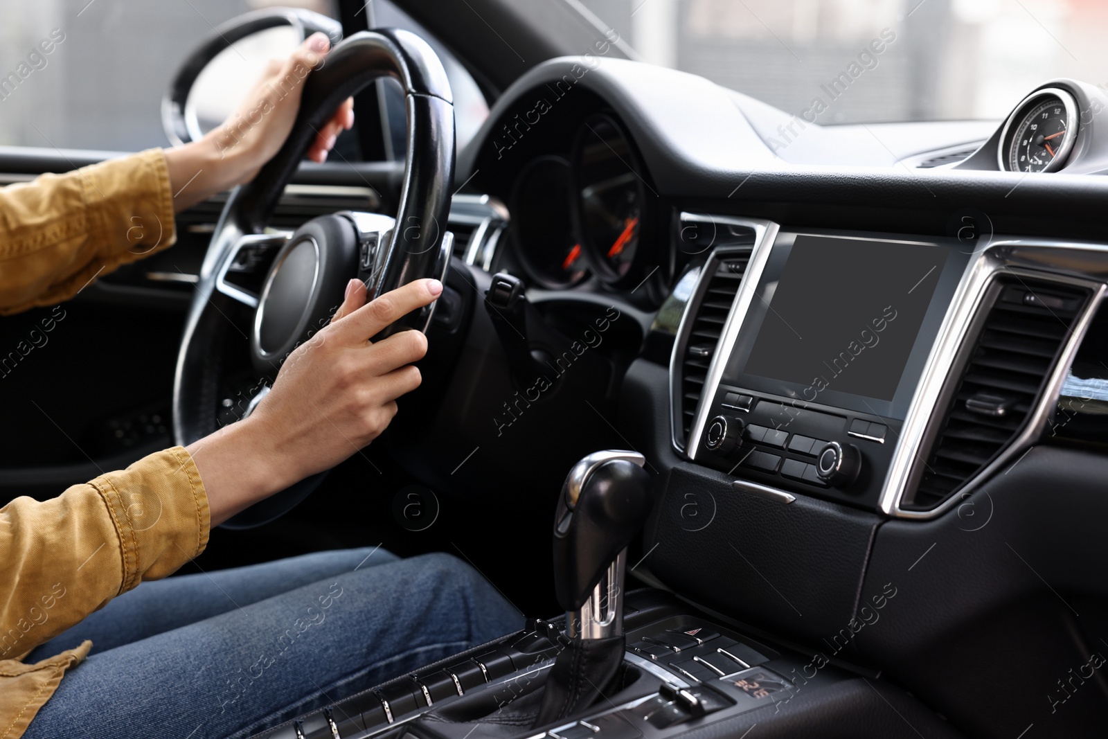 Photo of Woman using navigation system while driving her car, closeup