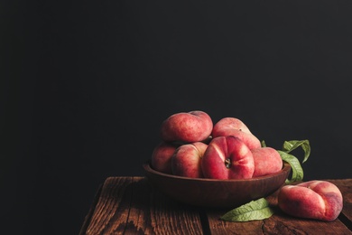 Photo of Fresh ripe donut peaches on wooden table. Space for text