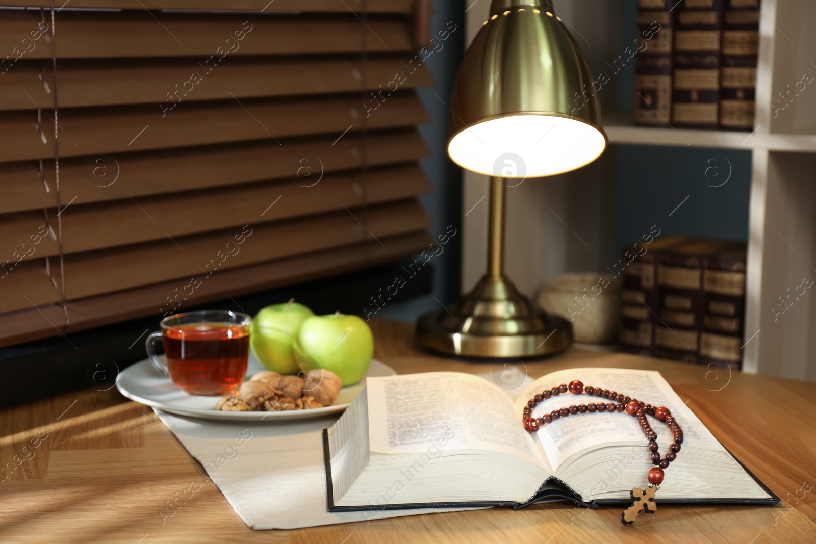 Photo of Holy Bible with prayer beads and snacks on wooden table indoors. Great Lent season