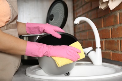Photo of Young woman cleaning modern multi cooker in kitchen, closeup