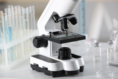 Photo of Modern medical microscope on white table in laboratory, closeup