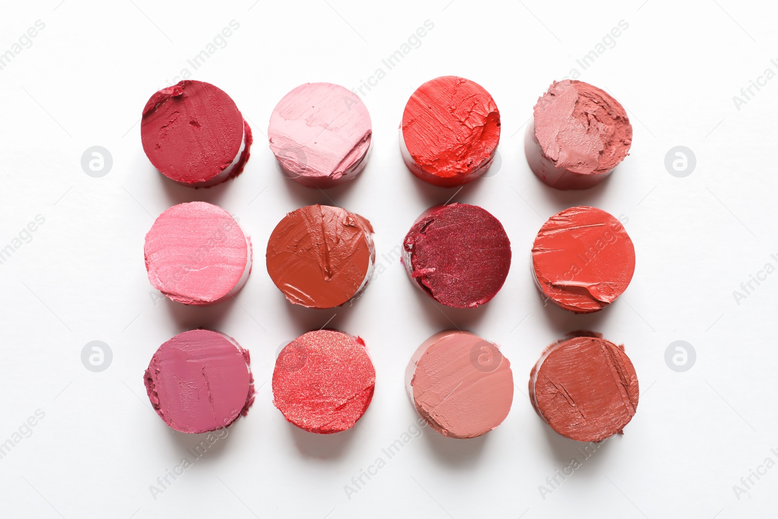 Photo of Different lipstick swatches on white background, top view