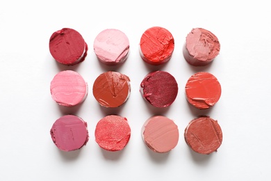 Photo of Different lipstick swatches on white background, top view