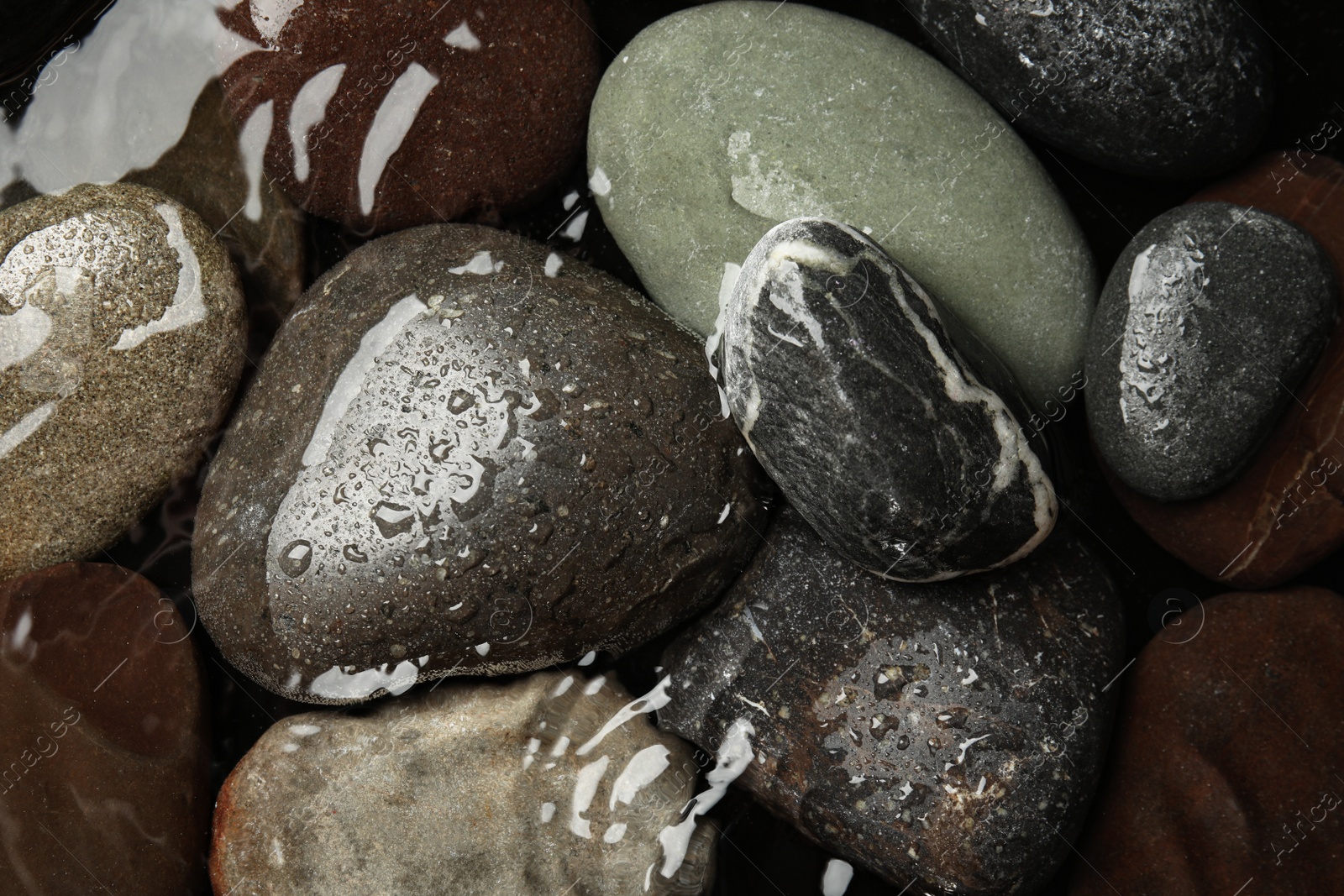Photo of Pile of stones in water as background, top view. Zen lifestyle