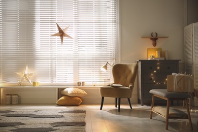 Photo of Bright room decorated with festive lights and stars