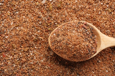 Photo of Closeup of wooden spoon with ground mixed pepper, top view