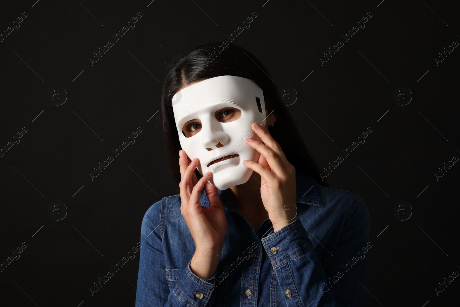 Photo of Multiple personality concept. Woman in mask on black background