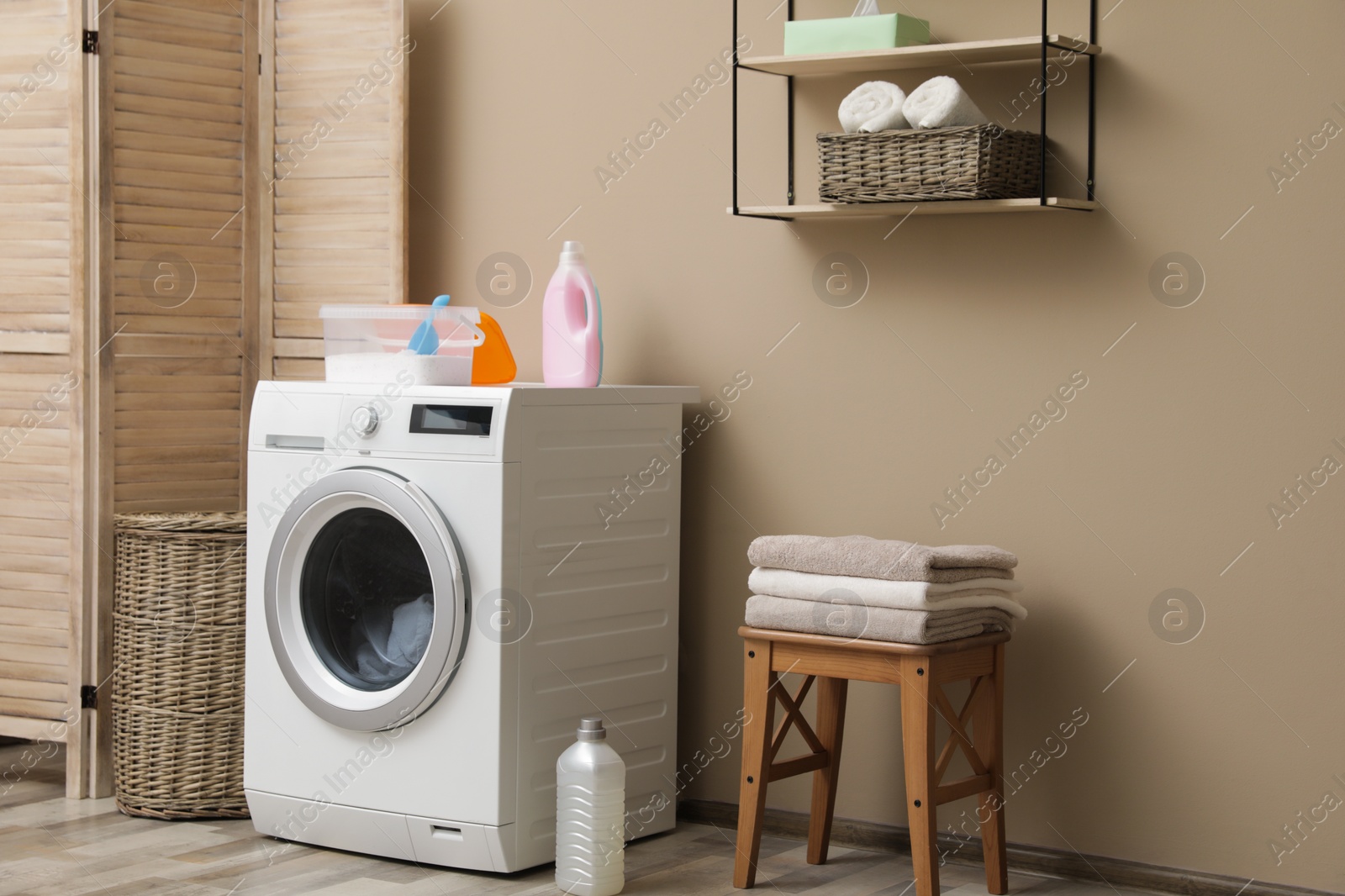 Photo of Modern washing machine near color wall in laundry room interior. Space for text