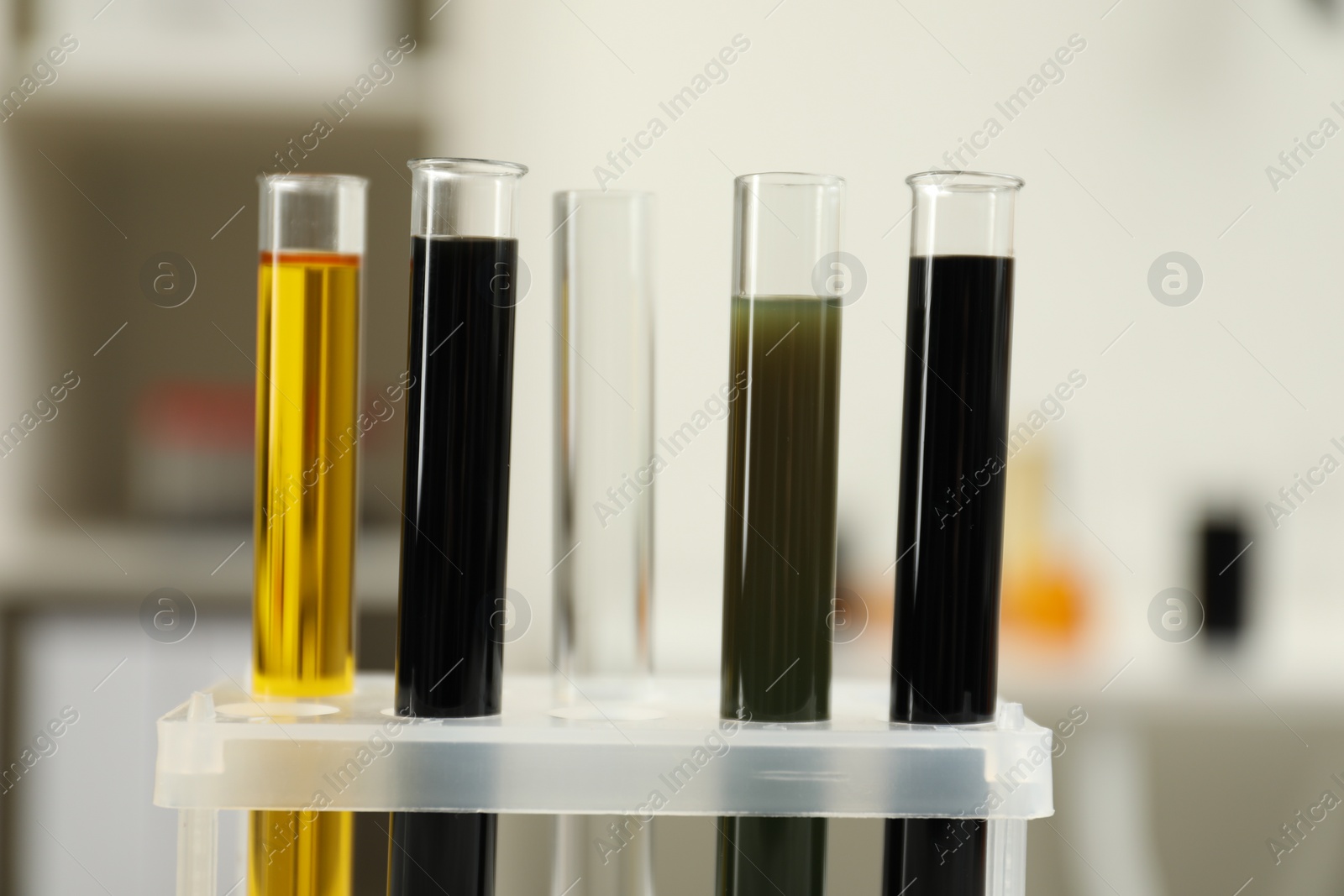 Photo of Test tubes with different types of crude oil against blurred background
