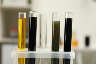 Test tubes with different types of crude oil against blurred background