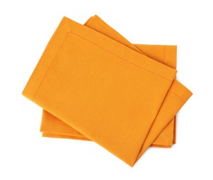 Photo of New clean orange cloth napkins isolated on white, top view
