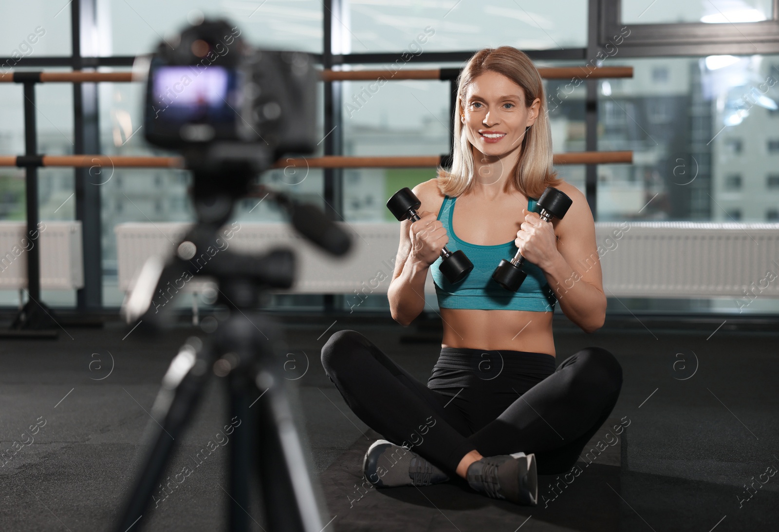 Photo of Fitness trainer recording online classes in gym