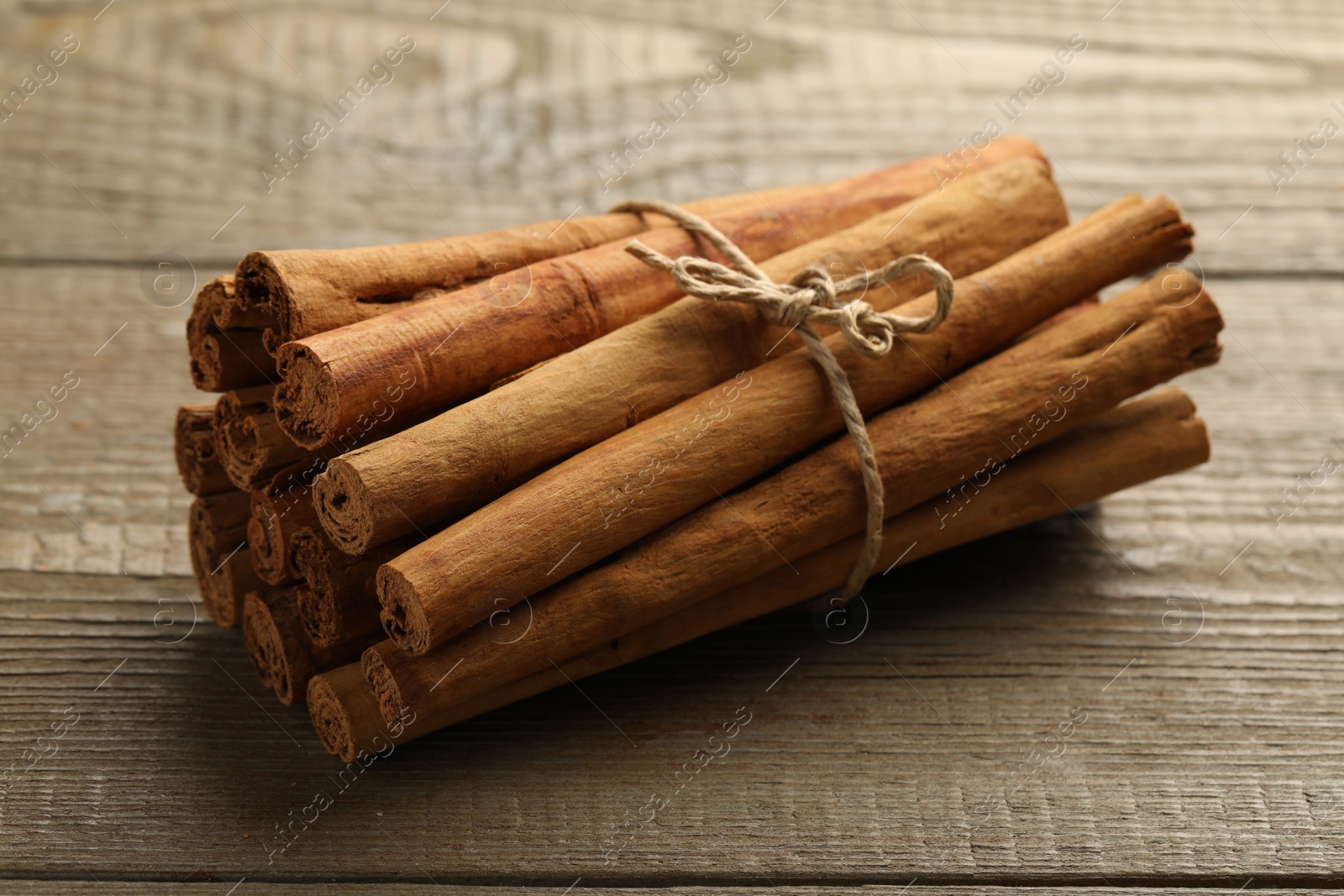 Photo of Many aromatic cinnamon sticks on wooden table
