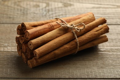 Photo of Many aromatic cinnamon sticks on wooden table