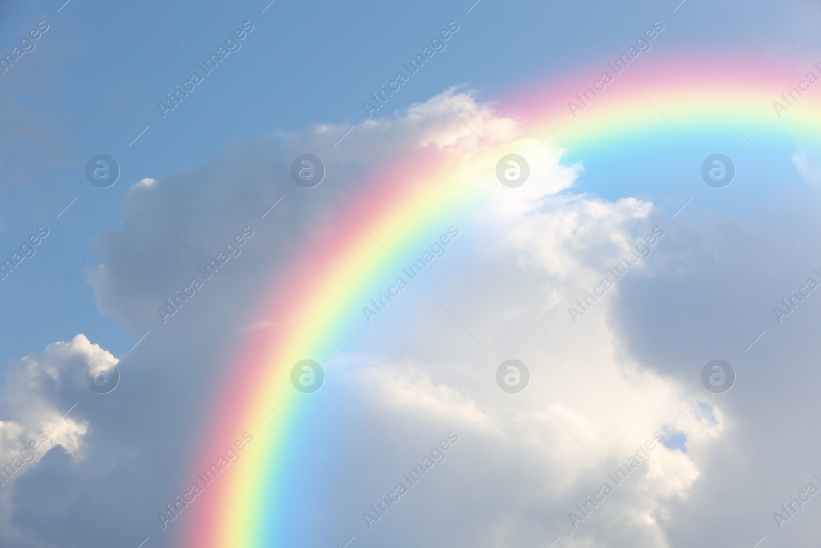 Image of Picturesque view of beautiful rainbow and blue sky on sunny day 