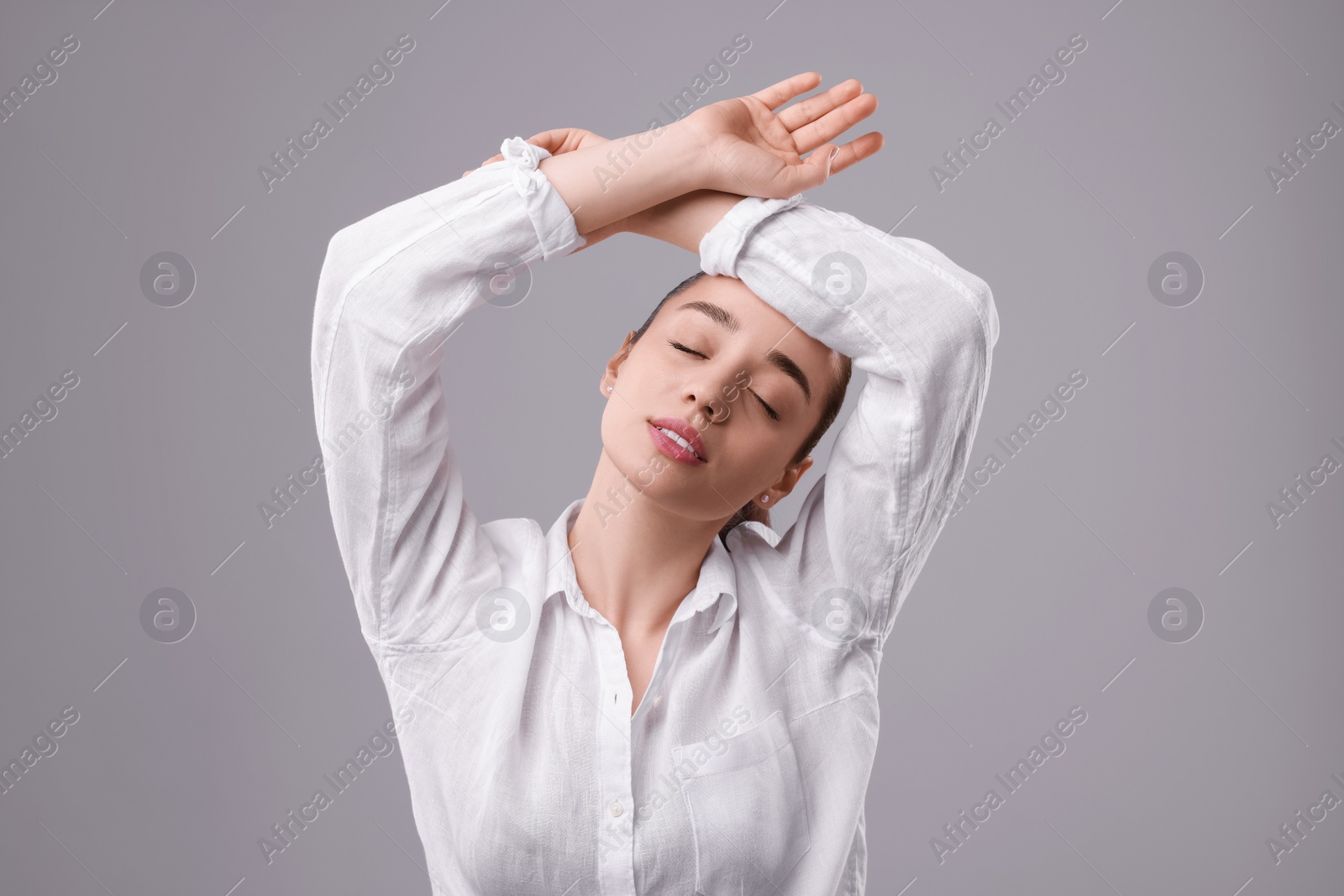 Photo of Portrait of beautiful young woman posing on light grey background