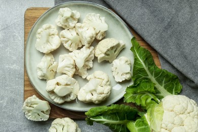 Cut and whole cauliflowers on grey table, flat lay