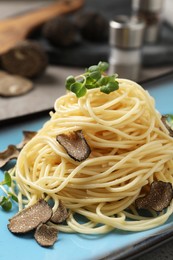 Photo of Delicious pasta with truffle slices and microgreens on plate, closeup