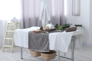 Photo of Rolled towel and spa products on massage table in recreational center