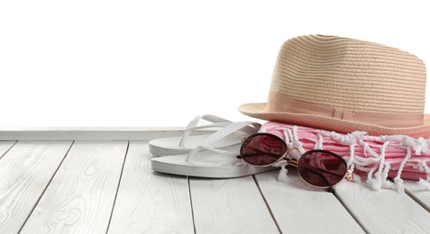 Hat, shoes, sunglasses and blanket on white wooden table, space for text. Beach accessories