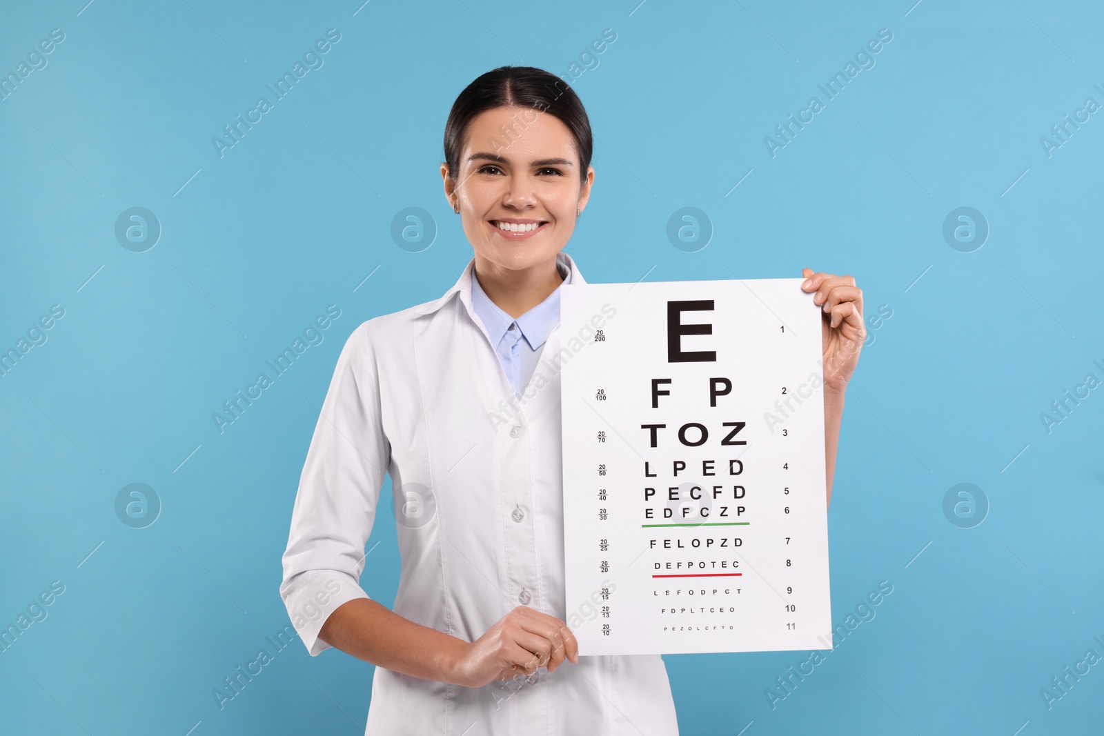 Photo of Ophthalmologist with vision test chart on light blue background