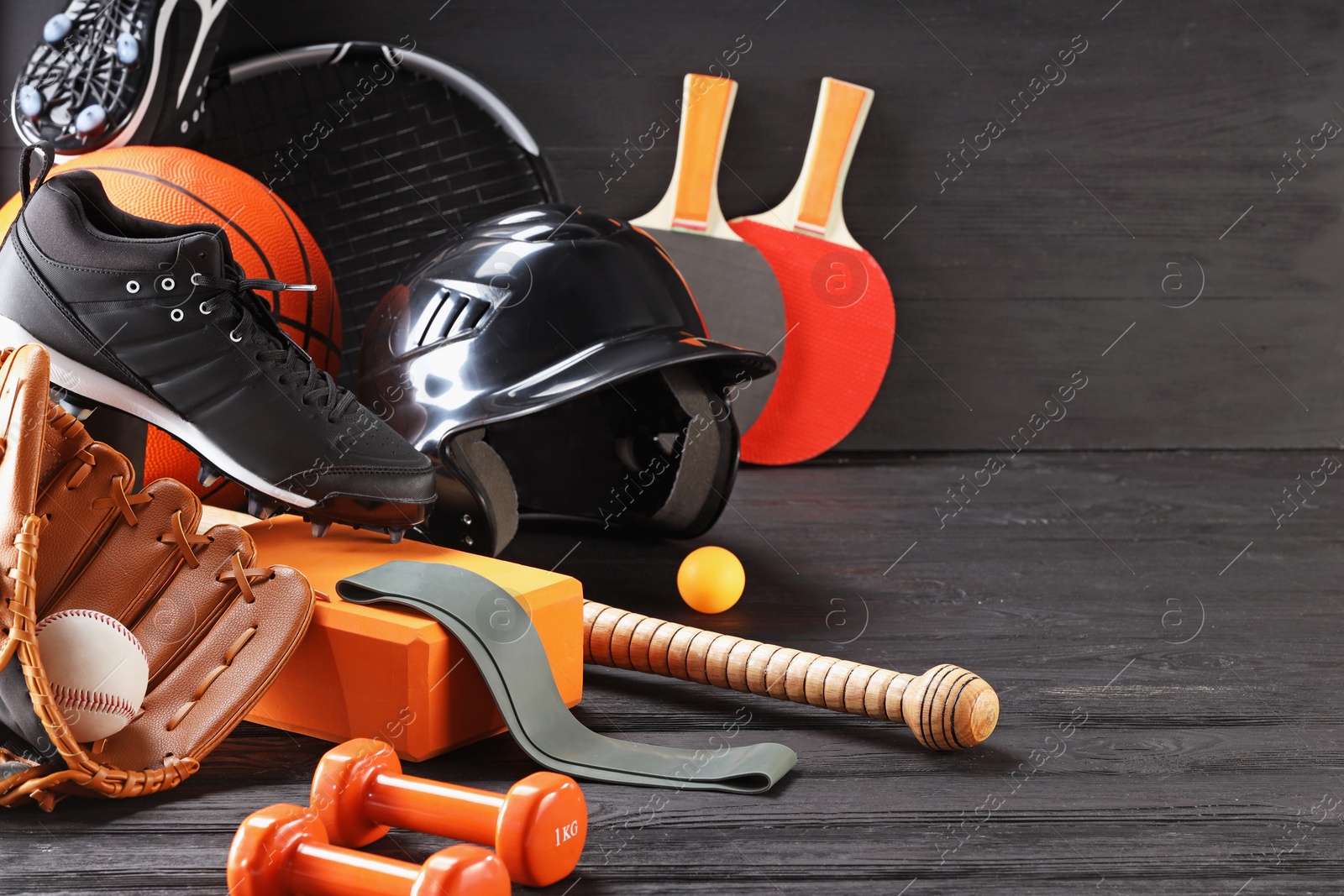 Photo of Many different sports equipment on dark grey wooden table, space for text