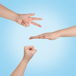 People playing rock, paper and scissors on light blue background, top view