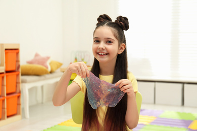 Little girl playing with slime in room