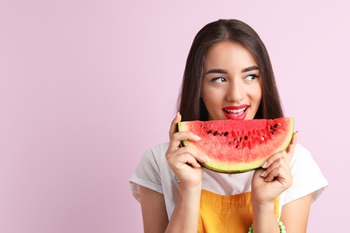 Photo of Beautiful young woman posing with watermelon on color background