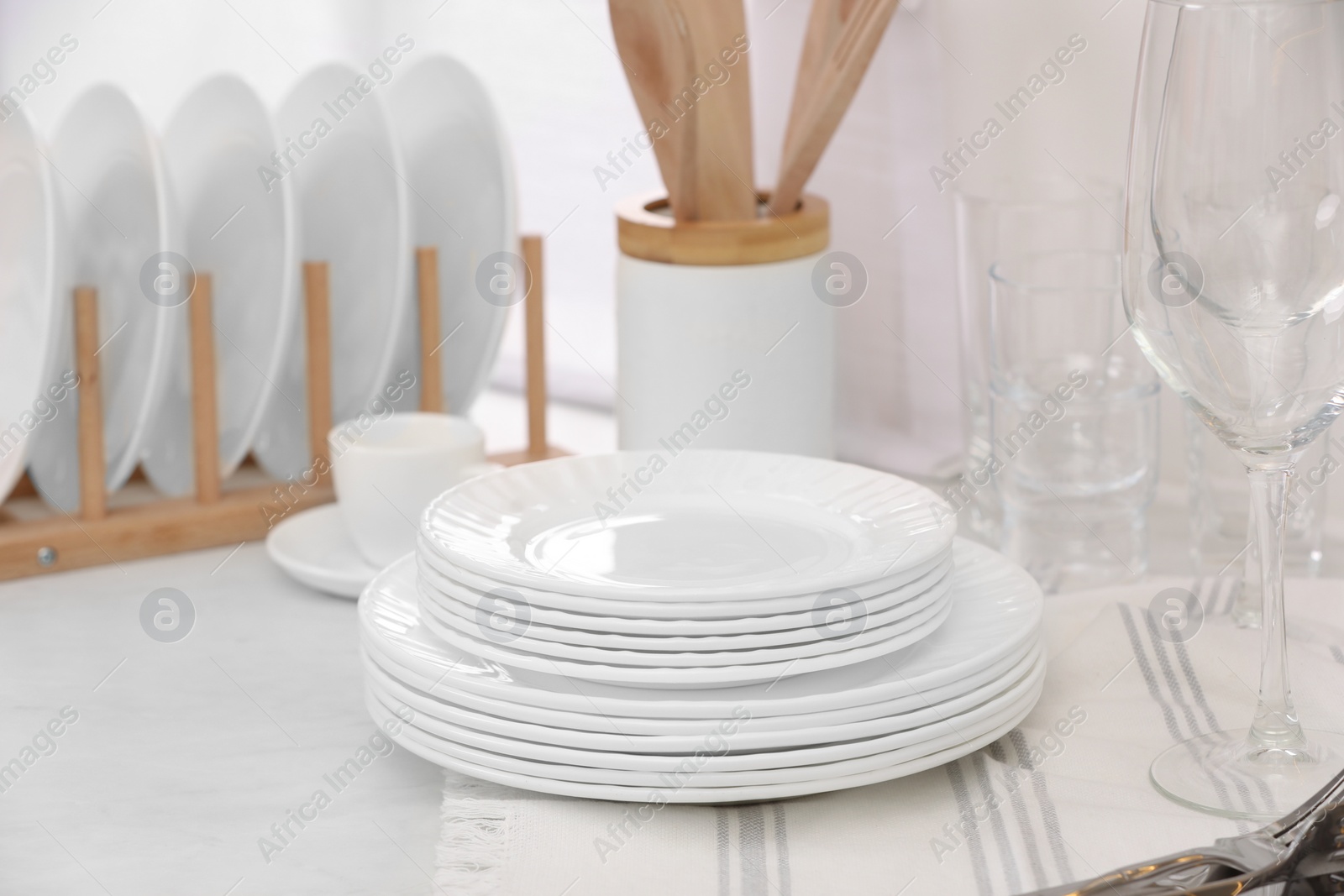 Photo of Clean dishes and towel on table in kitchen