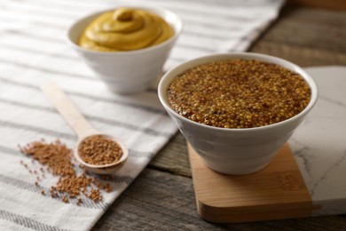 Photo of Bowl of whole grain mustard on wooden table, closeup. Space for text