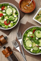 Photo of Tasty fresh salad with cucumber served on wooden table, flat lay