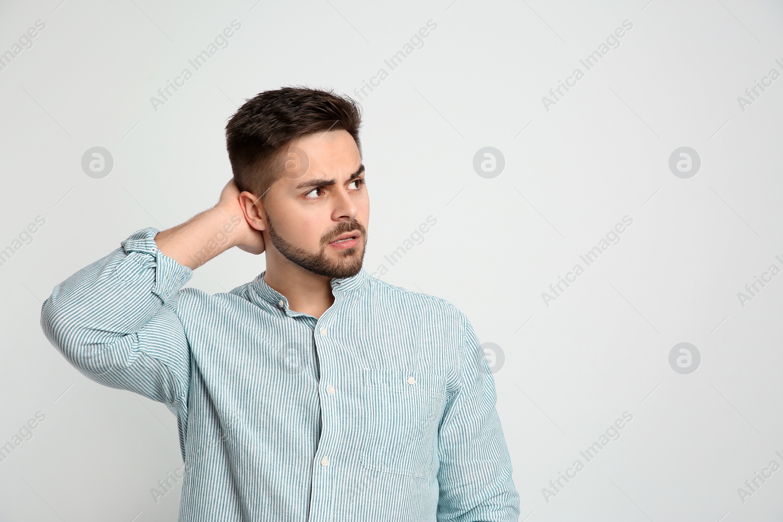 Photo of Pensive man on light background, space for text. Thinking about answer to question