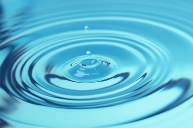 Photo of Splash of blue water with drop, closeup