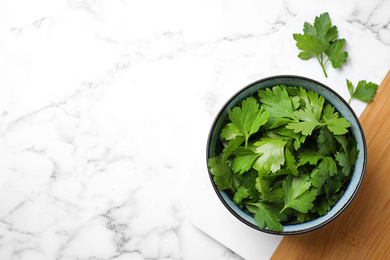 Photo of Fresh green parsley on white marble table, top view. Space for text