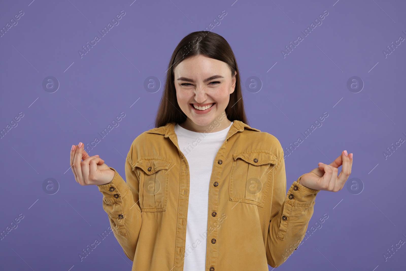 Photo of Happy woman showing money gesture on purple background