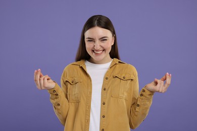 Photo of Happy woman showing money gesture on purple background