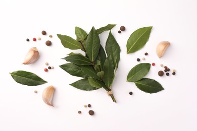Aromatic bay leaves and spices on white background, flat lay