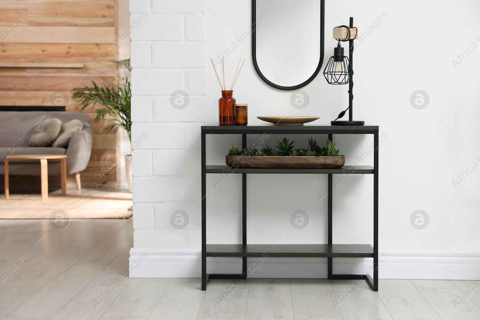 Photo of Console table with decor near mirror in room. Interior design