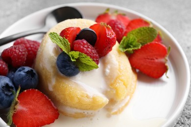 Photo of Delicious vanilla fondant served with fresh berries on grey table, closeup