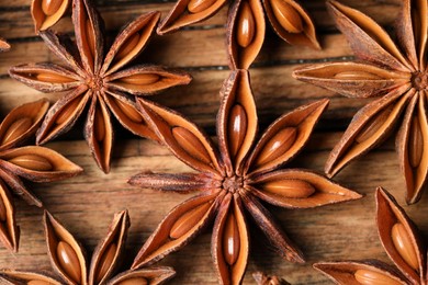 Photo of Aromatic anise stars on wooden table, flat lay