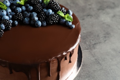 Fresh delicious homemade chocolate cake with berries on gray table, closeup