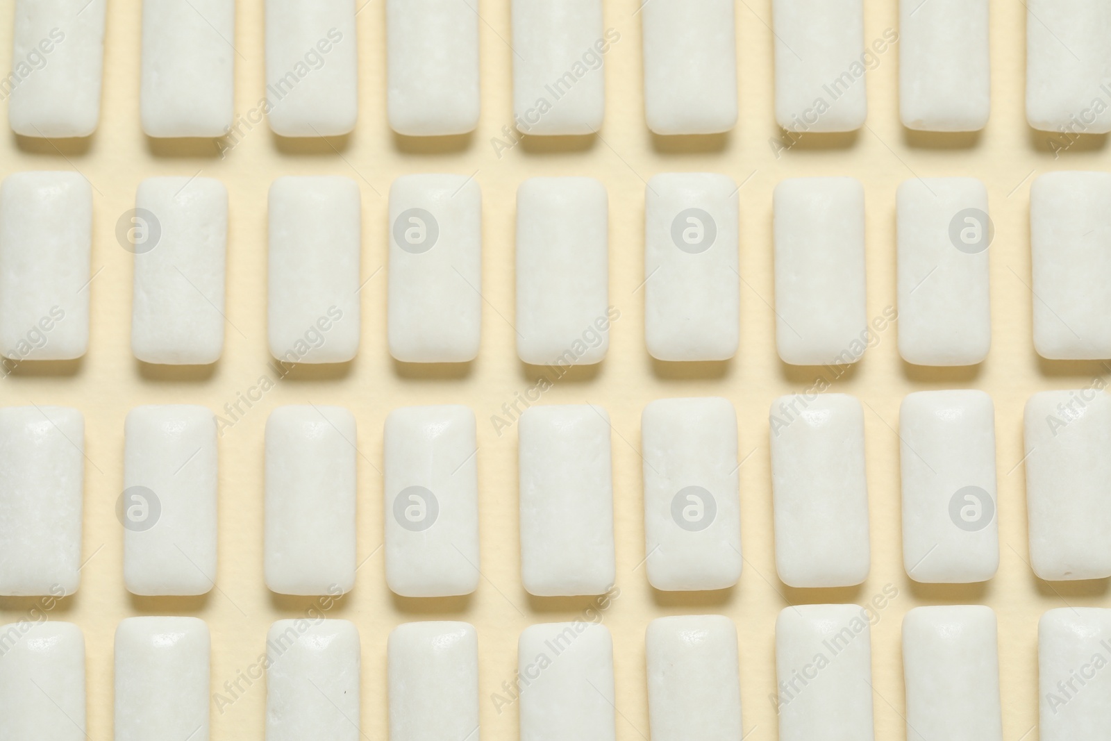 Photo of Tasty white chewing gums on beige background, flat lay