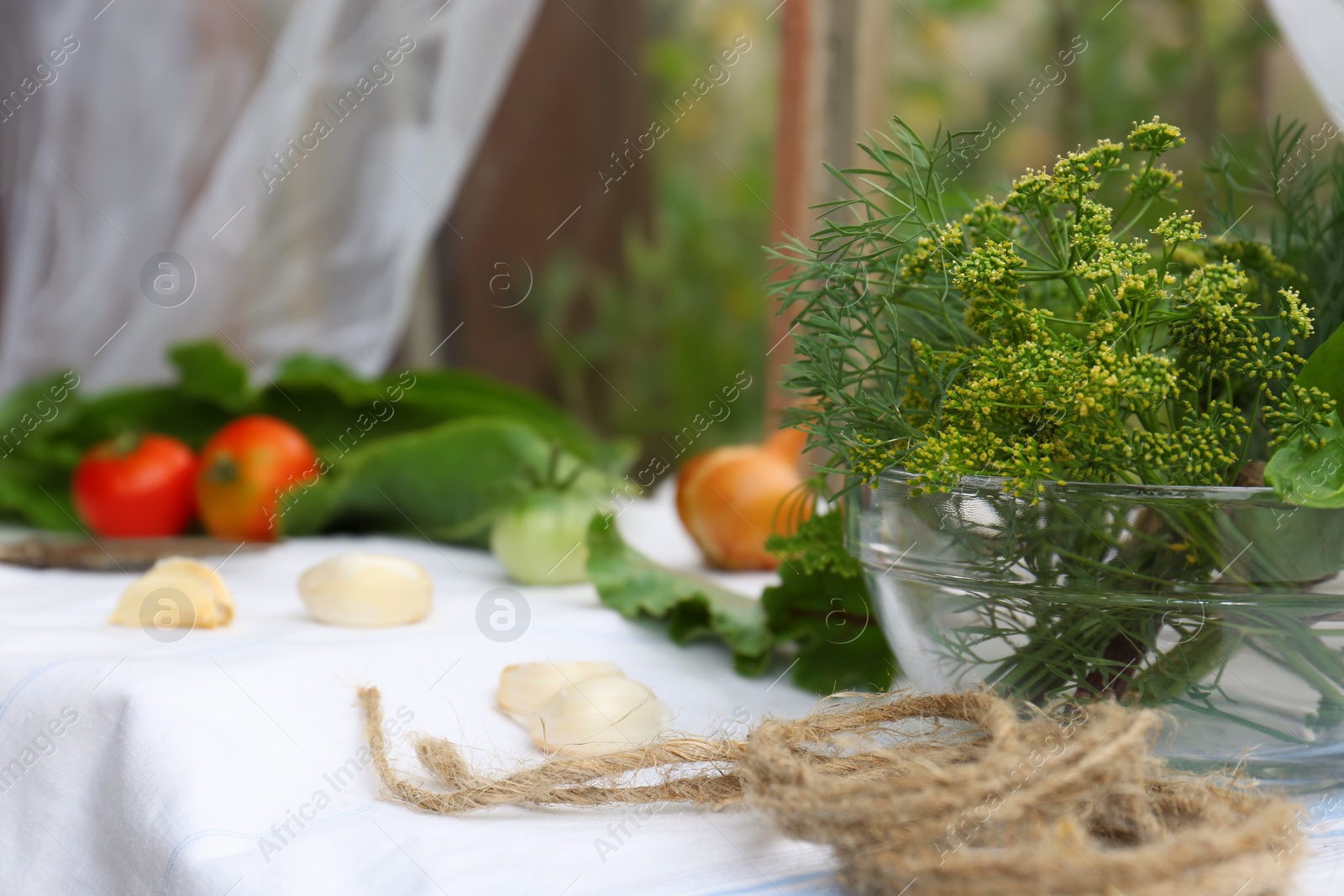 Photo of Fresh green herbs with twine on table indoors. Space for text